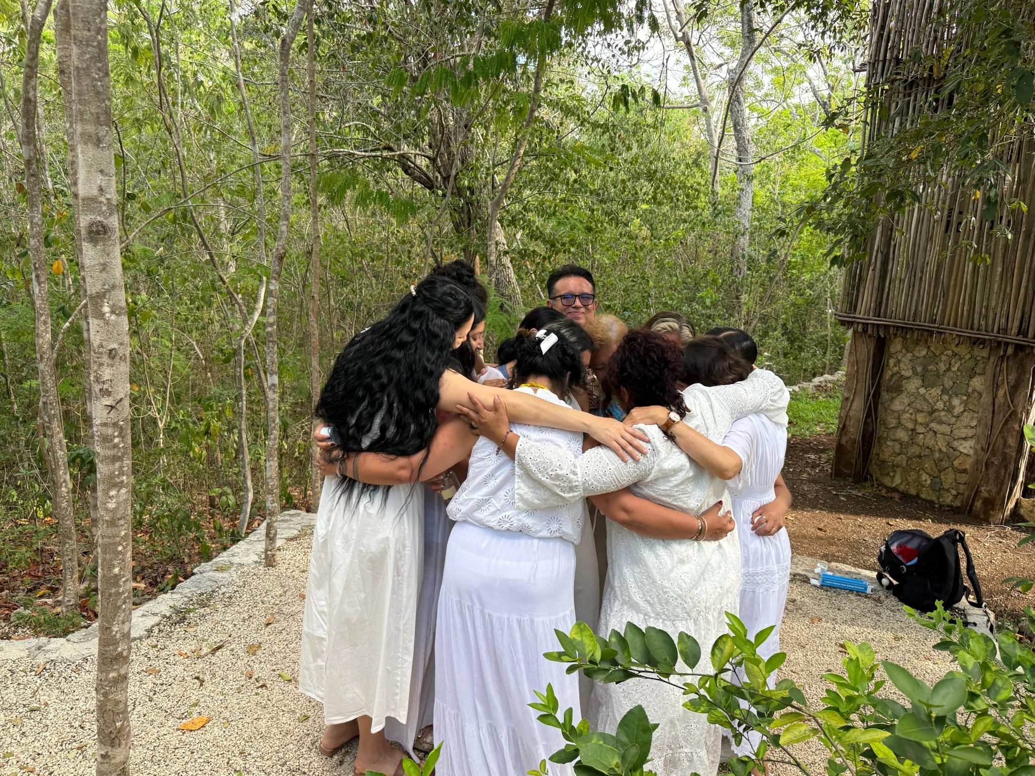 Grupo abrazándose en círculo durante el retiro en Tulum